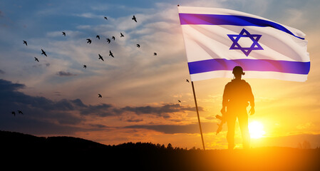 Silhouettes of soldiers with Israel flag and flying birds against the sunrise in the desert. Concept - armed forces of Israel.