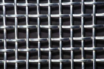 metal grid background
the rhythm of the cells of a steel shiny lattice on a dark background close-up