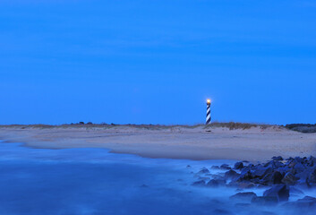 Early morning light and rocky shore at the Cape Hatteras Lighthouse on the outer banks of North Carolina - 501949120
