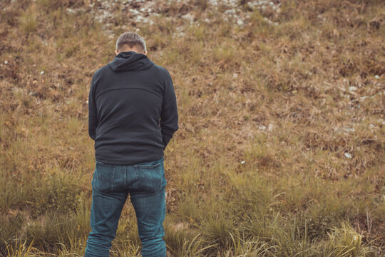 Back view of a person urinating at a motorway stop. Quick piss on the hard shoulder of a motorway.