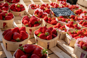 Sweet ripe french red strawberries in wooden boxes on Provencal farmers market, Cassis, France....
