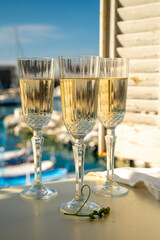 Three glasses of French champagne sparkling wine and view on colorful fisherman's boats in old harbour in Cassis, Provence, France