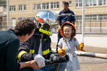 Fire uniformed father teaches his daughter Firefighter training