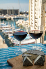 Summer party with red wine and cheeses on outdoor terrace with view on old fisherman's harbour with...