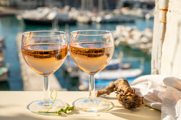Summer party with cold rose wine in glass served on outdoor terrace in sunlights with view on old...