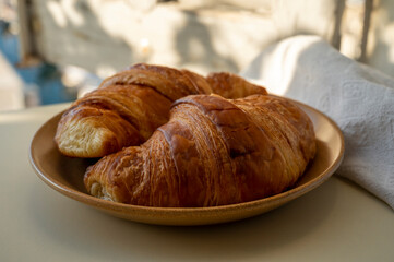 Summer morning in Provence, breakfast with fresh baked croissants and view on fisherman's boats in harbour of Cassis, Provence, France