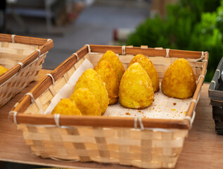 Sicilian food, deep fried rice croquettes with different fillings on market