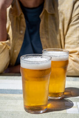 Men with two glasses of fresh cold lager beer in French outdoor cafe