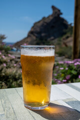 Glass of fresh cold lager beer served outdoor in snack bar with view on Calanque de Figuerolles in La Ciotat, Provence, France