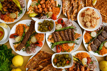 Delicious meat kebab with fresh vegetable salad served with variety of Turkish dishes and appetizers. Top view of assorted Turkish food and meze, tasty and healthy Mediterranean cuisine.