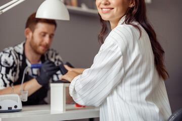 Manicure specialist providing nail service for client in salon