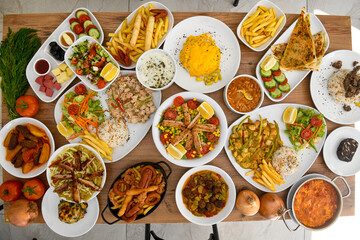 Traditional Turkish cuisine. Pizza, pita, pidesi, sucuk, hummus, kebab. Many dishes on the table. Serving dishes in restaurant. Background image. Top view, flat lay