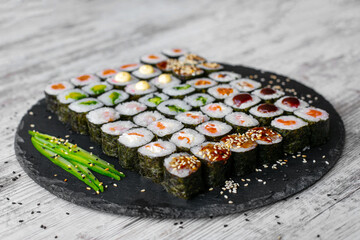 Sushi roll with salmon, tuna, avocado and cucumber. Traditional japanese food. A lot of maki. Sushi rolls.