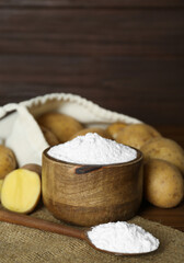 Starch and fresh raw potatoes on table. Space for text