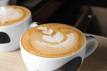 Cups of fresh aromatic coffee on table in cafe, closeup