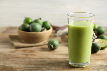 Fresh feijoa smoothie in glass on wooden table, closeup. Space for text