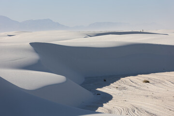 Gypsum sand dunes in White Sands National Park with blowing sand in the distance