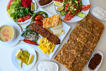 Traditional Turkish cuisine. Pizza, pita, pidesi, sucuk, hummus, kebab. Many dishes on the table. Serving dishes in restaurant. Background image. Top view, flat lay