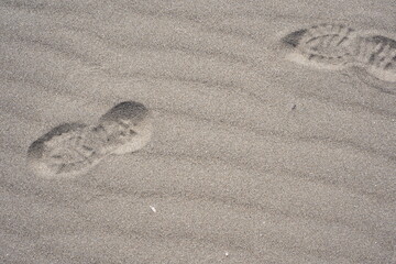 Fototapeta na wymiar 砂浜の足跡、砂と影、風、流砂、砂丘、陰影、気配、海水浴場、夏、砂利