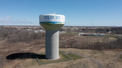 Aerial view of Tilbury water tower in the town of Tilbury, Ontario with wind turbines in the background.