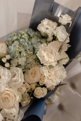 White - blue bouquet in blue packaging. White eustoma with blue hydrangea