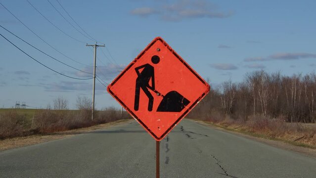 construction orange traffic sign on rural road clouds time lapse