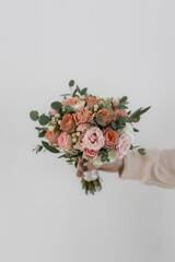 Wedding bouquet of the bride in delicate peach, beige and pink colors