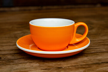 An orange coffee cup on a table