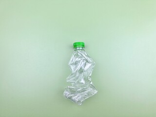 Eco-friendly degradable clear plastic bottle placed on a gradient reflections green background