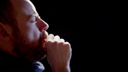 SLOW MOTION BACKLIT - A sick man with a virus coughing, studio black background