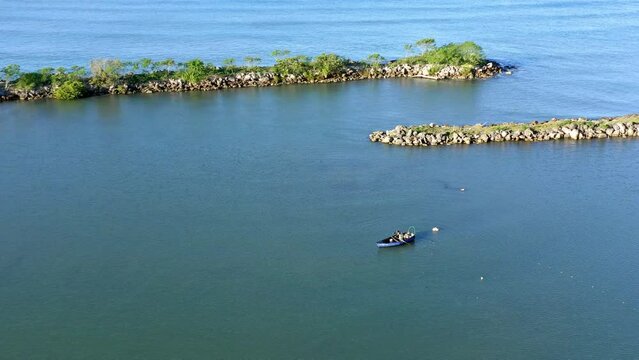 Fisherman in Soco River mouth with fishing criminal method, Dominican Republic. Aerial drone view