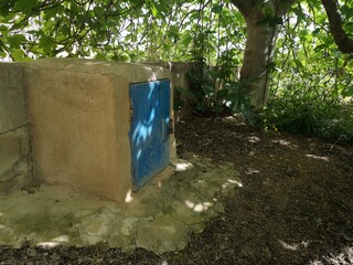 Wasserversorgung Anschluß Haus mit blauer Tür unter einem Feigenbaum