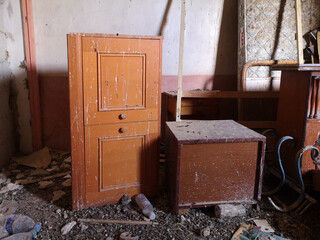 Verlassenes Einfamilienhaus mit alten Holzmöbeln und Taubenkot