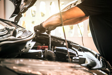 Close-up hand auto mechanic using the wrench to repairing car engine problem. Concepts of check and fix car and maintenance servicing.