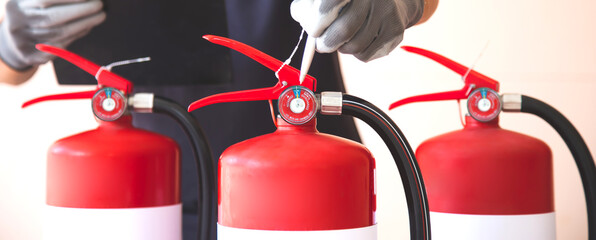 Naklejka premium Close up fire extinguisher and firefighter checking pressure gauge level for protection and prevent and safety rescue and use of equipment on fire training concept.