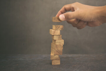 Hand place wooden block stacked concept of prevent collapse or crash of financial business and risk...
