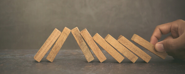 Hand place wooden block stacked concept of prevent collapse or crash of financial business and risk...