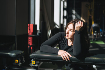 Fototapeta na wymiar Portrait of resting Young brunette woman in sport active wear in the fitness club