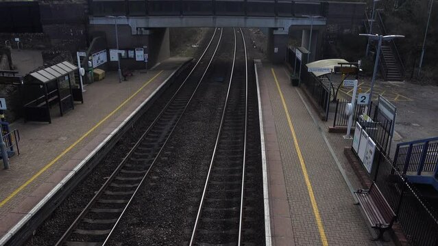 An express train thunders through a station at high speed