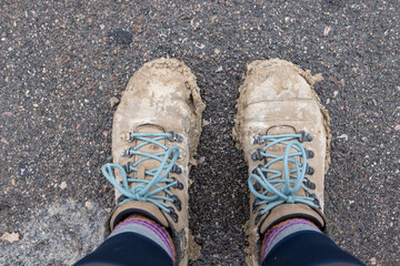 Hiking boots covered in mud from silt