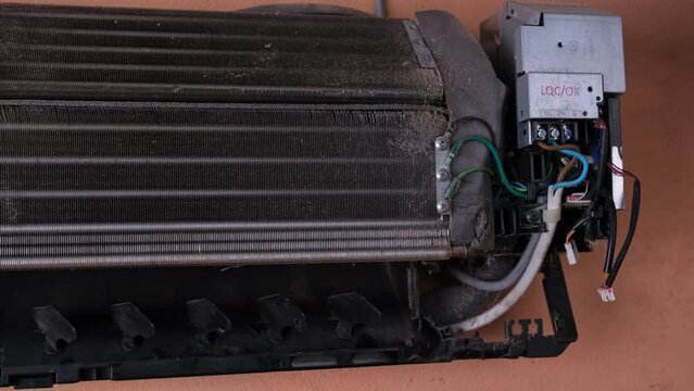 Camera moves along dirty air conditioner blower fan and cooling coil. The blower of the dusty indoor air conditioner, close-up. The concept of cleanliness and hygiene in the home.