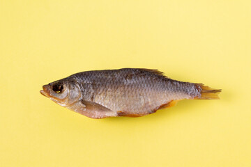 dried fish - rudd on a yellow background, isolate