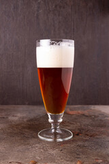 a glass of beer stands on a rusty iron sheet, side view
