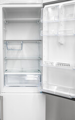 New clean refrigerator. Opened empty refrigerator. Refrigerator open empty fridge inside interior. close up on empty freezer with door open. empty shelves in open fridge