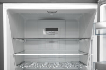 Empty fridge background, inside view into refrigerator with glassy shelfs, food storage concept. empty shelves for products. New clean refrigerator. Open empty fridge inside interior.