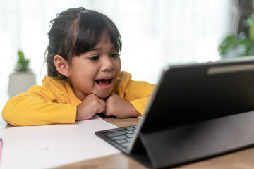 Asian little girl taking class on line and happy for Homeschool Quarantine coranavirus pandemic concept