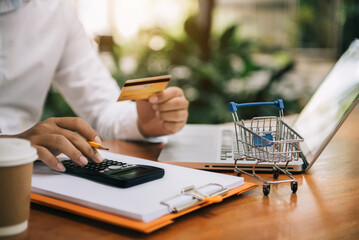 Online shopping concept, Male using calculator with credit card shopping online is a form of...