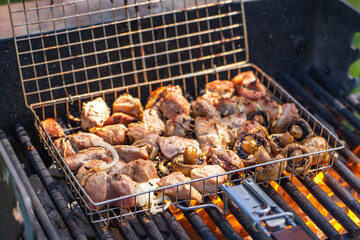 Pork skewers and mushrooms are cooked over an open fire. 