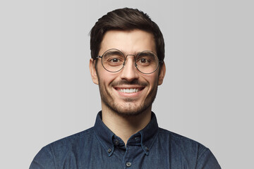 Headshot of European man wearing round eyeglasses and smiling