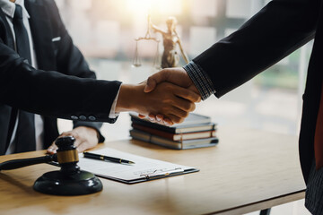 Businessman shaking hands partner lawyers or attorneys discussing a contract agreement.